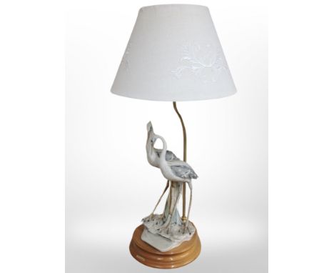 A Florence bisque porcelain table lamp modelled as two herons, together with a further example in the form of a lady, with sh