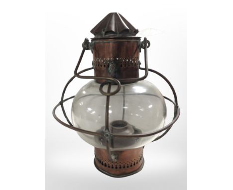 A 19th-century copper and glass oil lamp with swing handle, height 37cm.