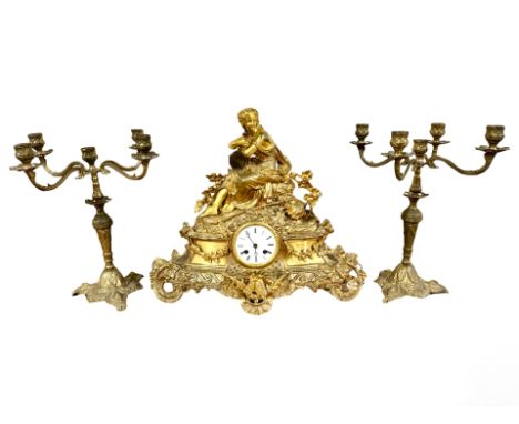 A 19th century French gilt metal figural mantel clock, with a pair of similar candlesticks, striking on a bell, with pendulum