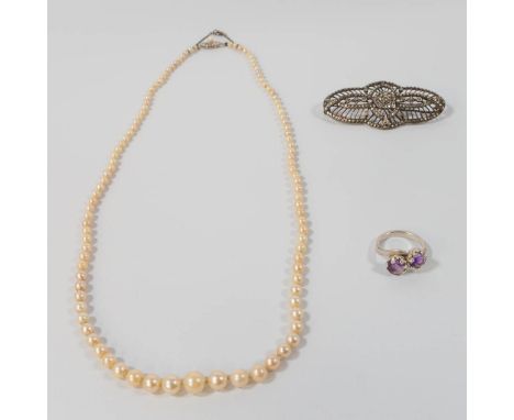 A pearl necklace with 18 karat gold buckle, combined with a silver ring with purple stones and a brooche. 