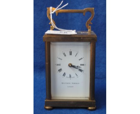 Matthew Norman brass carriage clock with full depth Roman numeral enamel face.