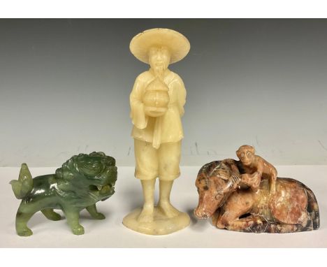 A 19th century Chinese hardstone figure, a man holding a lidded pot, 15.5cm high; another, a jade Fo dog, 6cm high, 7.5cm lon