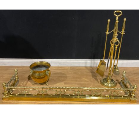 A 19th century Neo-Classical brass fire curb or fender, 20cm high, 138cm wide, 35cm deep; a brass fireside companion set, on 