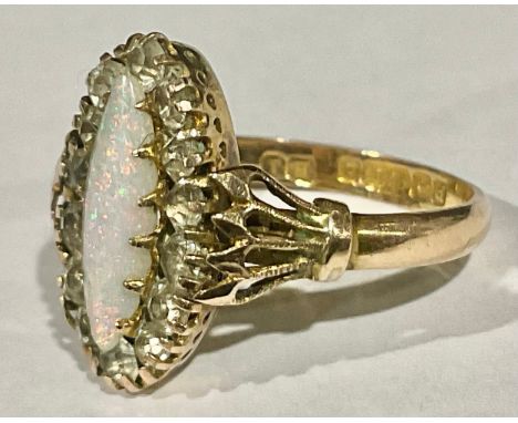 A 9ct Rose Gold Opal and Spinel ring, the ring is set with a marquise shaped cabochon opal piece in the centre  that measures