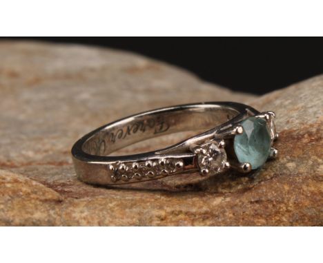 A diamond and blue topaz ring, round pale blue topaz approx 0.50ct, mounted between principle round brilliant cut diamonds, a