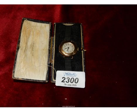 A 375 gold cased ladies wrist Watch by J.W. Benson, London, with a fabric strap and 9ct gold fastening, cased.