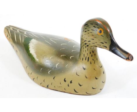 An early  20thC folk art wooden decoy duck, with painted plumage predominantly in green and grey, probably French, 15cm high.