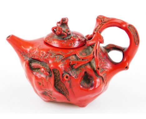 A Chinese teapot, raised with flowers and insects with naturalistic bark handle, plain spout and removable lid, mark beneath,