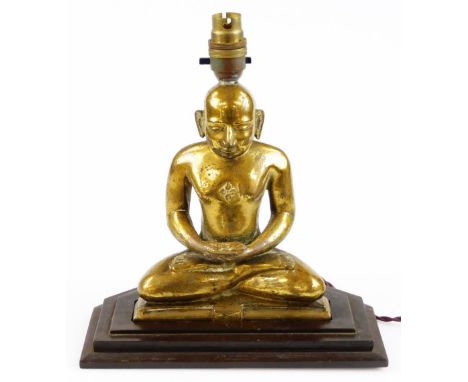 A 19thC gilt metal figure of a seated Buddhistic monk, converted to a lamp, 20cm high plus stepped base. 