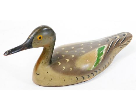An early 20thC folk art wooden decoy duck, with painted plumage predominantly in green and grey, probably French, 16cm high.
