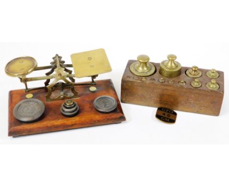 A set of Victorian brass and mahogany postal scales with weights, and a further oak block of weights. (2)