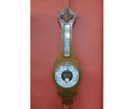 An Edward VII carved oak aneroid barometer