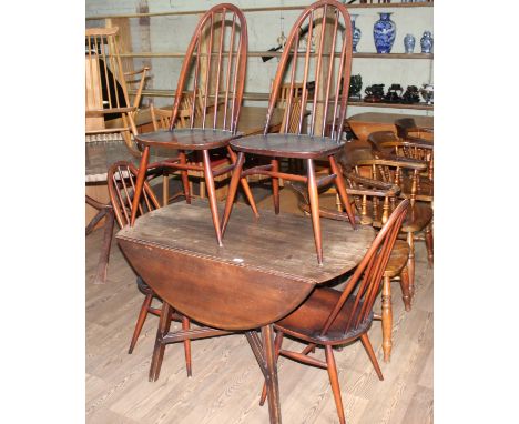 An Ercol dark elm and beech drop leaf table and four chairs.  