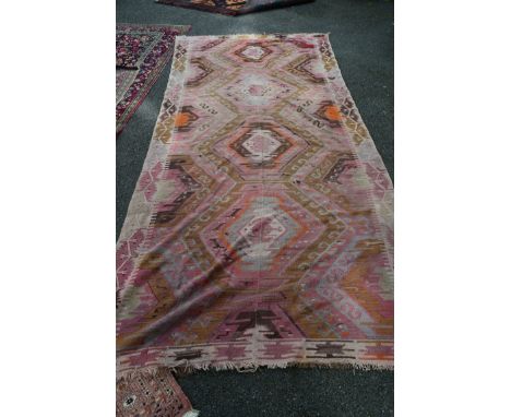 A large Turkish Kelim flatweave carpet, with four medallions woven in two halves and joined together, 340 x 160cm. 