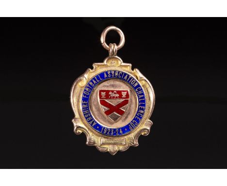 1924 AYRSHIRE FOOTBALL ASSOCIATION CHALLENGE CUP GOLD MEDAL, the obverse with central red enamelled shield shaped plaque, wit