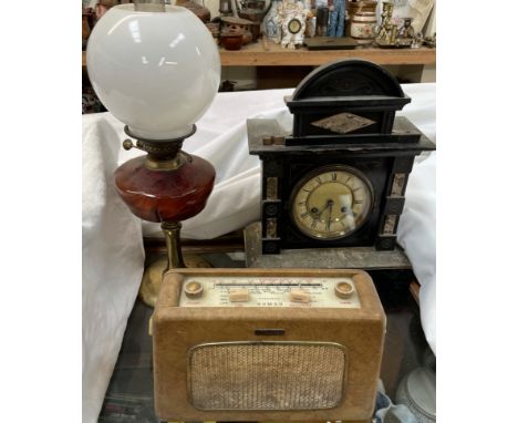 A simulated black slate mantle clock, together with a Dynatron Nomad radio and an oil lamp