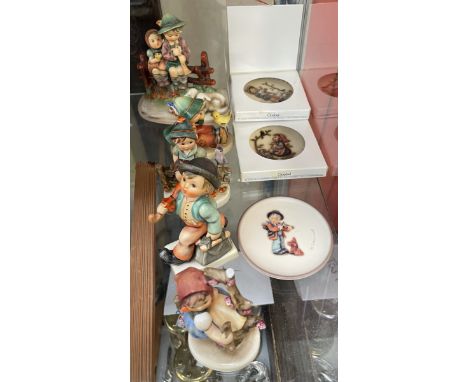 A Hummel figure of a young man with an umbrella over his shoulders together with other Hummel figures, plates etc