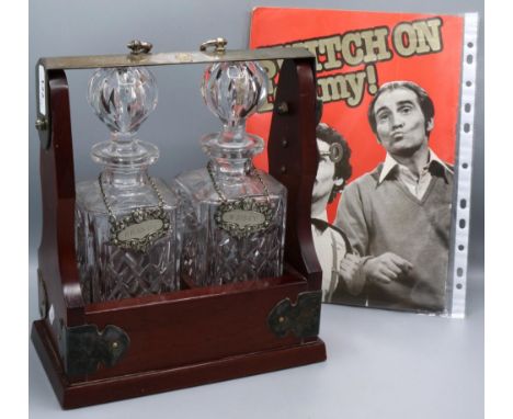Tommy Cannon Collection: two-bottle tantalus containing two glass decanters, hung with silver plate wine labels 'Whisky' and 