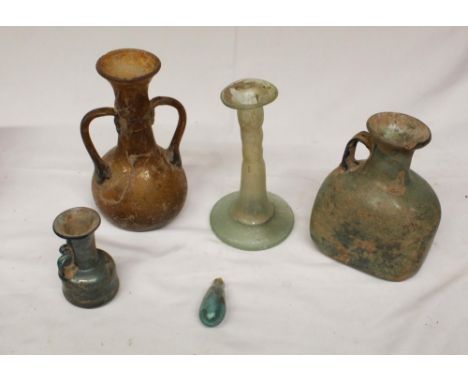 Collection of five glassware antiquities of various styles and periods, to include a candlestick, jugs etc. possible Roman in