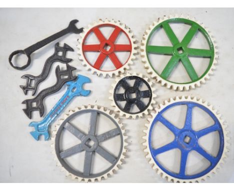 Collection of vintage cast steel cogs (repainted) and 4 spanners/wrenches, one marked Nicholsons. Largest cog diameter 24.7cm