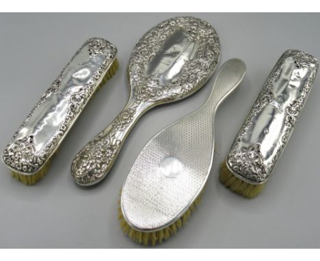 Victorian silver three piece dressing table set incl two brushes and hand mirror with floral repousse decoration by Henry Mat