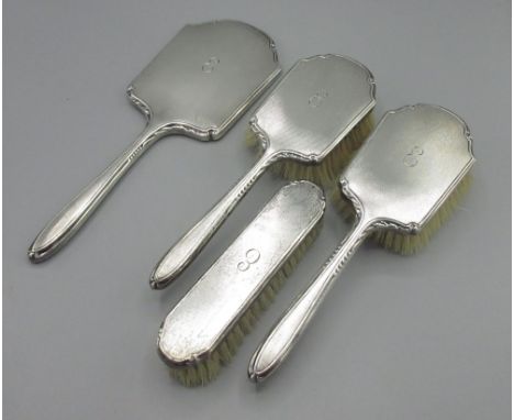 20th century silver dressing table set including three brushes and a mirror monogrammed with engine turned pattern by Albert 