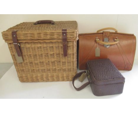 Wicker picnic basket with fitted interior and leather straps, a Cygnet brown leather brief case and a Revlon vanity case (3) 