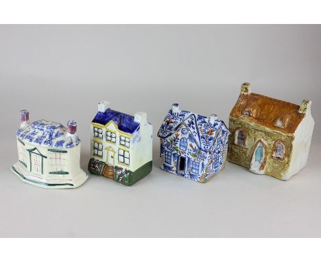 Three Staffordshire pottery money boxes modelled as houses, together with a Delftware pottery house
