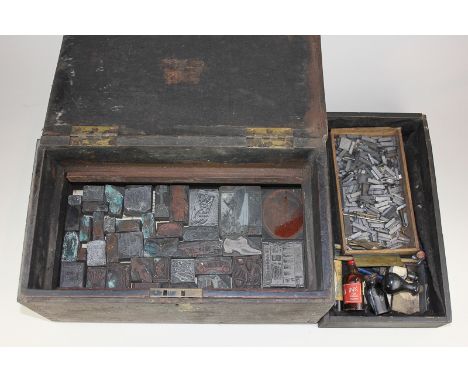 A collection of printing blocks and letters in a wooden box with other print related items