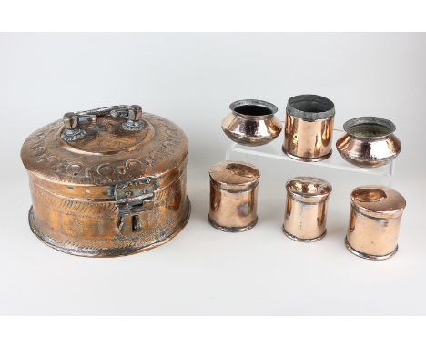 A Nepalese copper spice storer, the embossed lid lifting to expose a lift-out copper shelf revealing two pots and three lidde