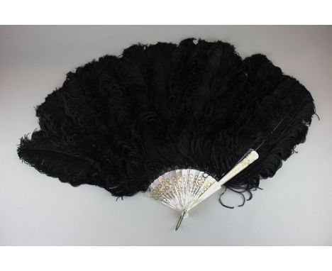 An inlaid mother of pearl and black ostrich feather fan, 19cm spokes