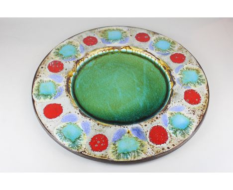 A large mid 20th century studio pottery charger with bright enamel design, marked West Germany to reverse, 43cm