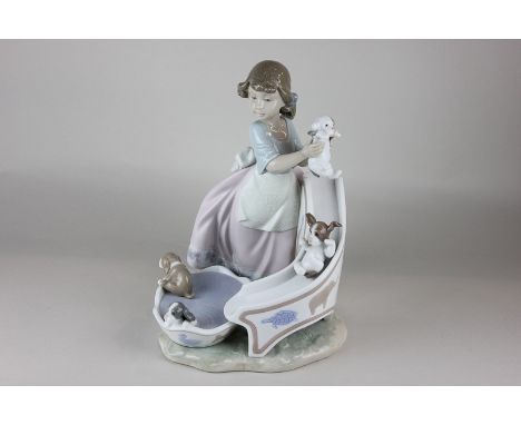 A Lladro porcelain figure of Down you go (6002) of girl playing with puppies on a slide, 25cm
