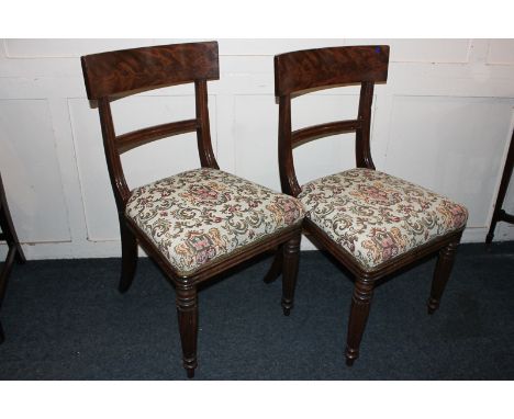 A pair of 19th century mahogany dining chairs with curved back supports, tapestry seats on reeded legs