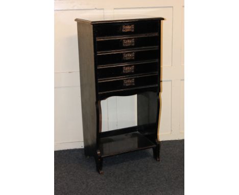 An ebonised music cabinet of five drawers over open shelf, 49cm