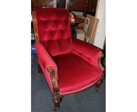 A Victorian armchair in red button back upholstery, on turned legs and castors