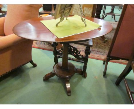 A pair of Arts &amp; Crafts mahogany lamp tables the chamfered edge oval tops over tapering square column and circular platea