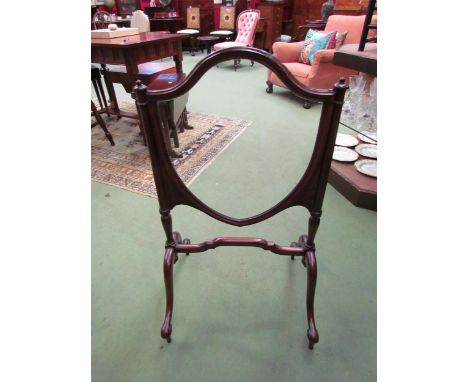 A Victorian mahogany shield shape fire screen on scroll form feet, 89cm high x 50cm wide 