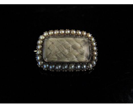 A 19th Century gold memoriam brooch with woven hair panel framed by pearls, to verso "Mary Horne, died April 15th 1881, ages 