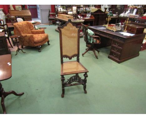 A walnut hall chair carved in Carolean style pierced with fretwork panel to front, cane work seat pad and back rest 