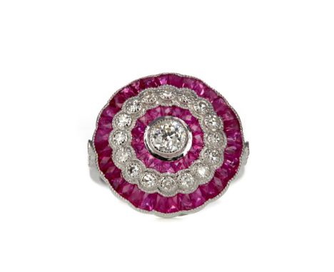 RUBY AND DIAMOND RING, the central old cut diamond bordered by calibre cut rubies and round brilliant cut diamonds with furth