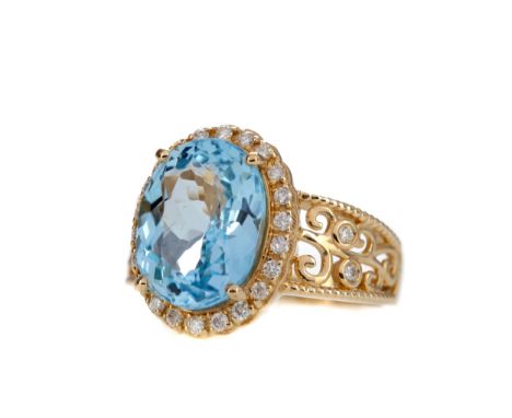 TOPAZ AND DIAMOND RING, set with an oval topaz of approximately 5.92 carats, within a diamond halo, with diamonds to the open