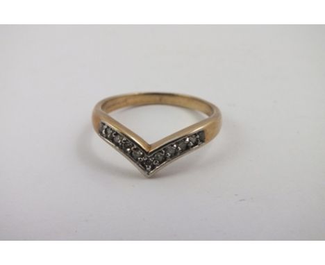 A 9CT GOLD DIAMOND SET RING of chevron form 