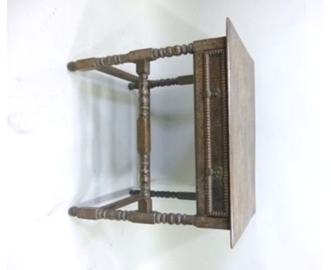 A 20TH CENTURY JACOBEAN STYLE SIDE TABLE, having plank top with moulded edge over a single drawer frieze, raised on bobbin an