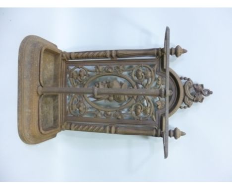 A LATE VICTORIAN CAST IRON UMBRELLA/STICK STAND, having pierced fruit panel back, fitted with two removable drip pans, 74cm h