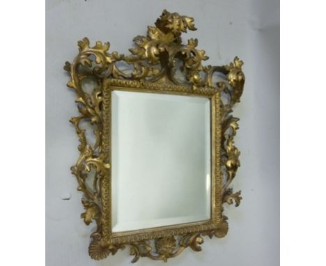 A CARVED AND GILT WOOD FRAMED FLORENTINE WALL MIRROR, having deep acanthus leaf design, bevel plate, mirror 30cm x 25cm 
