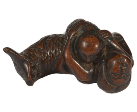 A JAPANESE WOOD NETSUKE OF A NURSING MERMAID, EDO PERIOD, CIRCA 1790 a characterful old carving, unsigned 5.5cm long Provenan