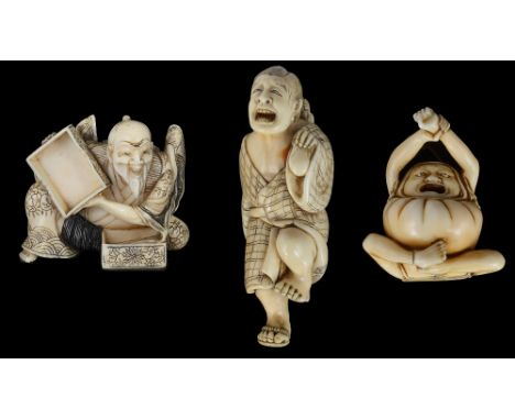 ˜A GROUP OF THREE JAPANESE IVORY NETSUKE, MEIJI PERIOD (1868-1912) comprising: a study of Daruma, carved stretching and yawni