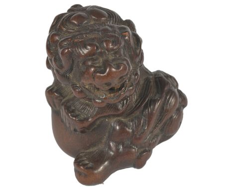 A JAPANESE PLUM WOOD NETSUKE OF A SHISHI, MID EDO PERIOD, CIRCA 1780 in the style of Mitsuharu, clutching a large ball, unsig