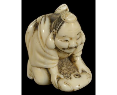 ˜A JAPANESE WALRUS IVORY NETSUKE OF EBISU, MEIJI PERIOD (1868-1912) the lucky god holding down a large tai fish, unsigned 3.2